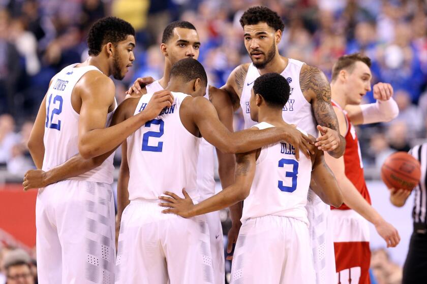 Kentucky players -- including NBA-bound Aaron Harrison (2), Karl-Anthony Towns (12), Trey Lyles (back, center) and Willie Cauley-Stein (back right) huddle their Final Four game against Wisconsin.