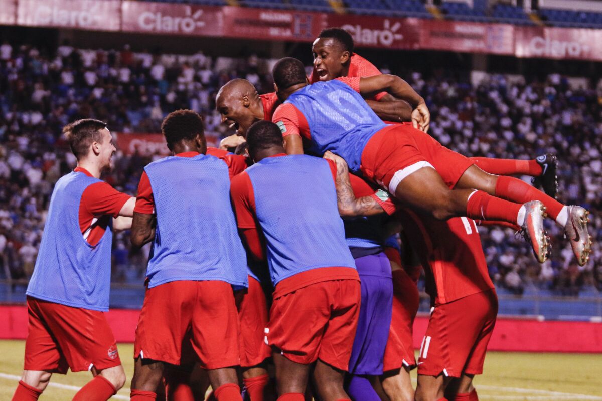 Canada's Jonathan David is congratulated by teammates after scoring against Honduras