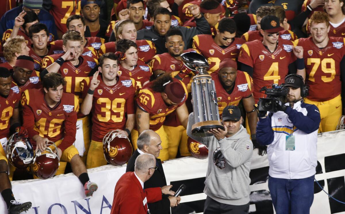 USC Coach Steve Sarkisian holds up the Holiday Bowl trophy after the Trojans' 45-42 victory over Nebraska on Saturday.
