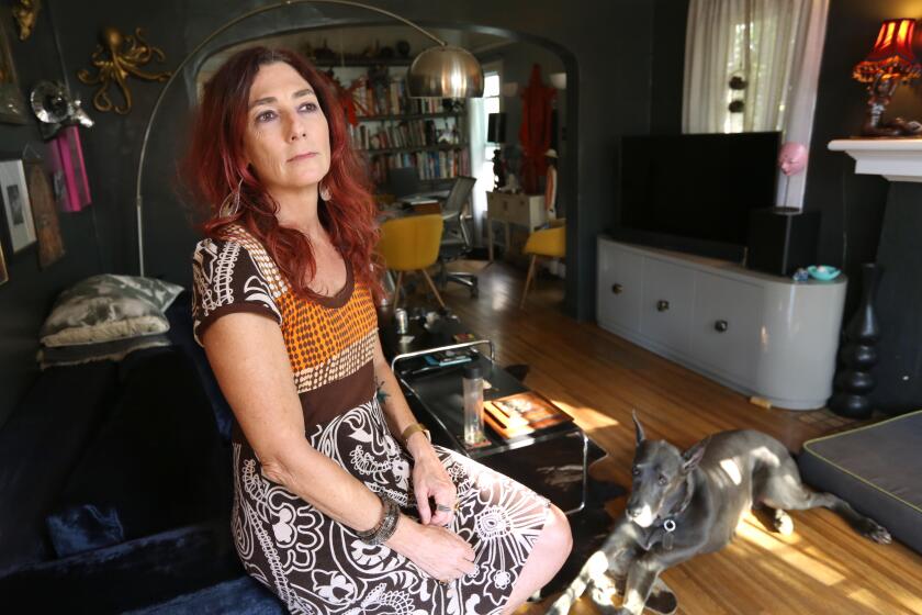 LOS ANGELES, CA - JULY 20, 2023 - "At this moment, I'm not really making ends meet," said Andi Brittan, a set decorator in Hollywood, sitting in the living room with her dog Memphis at her home in Los Angeles on July 20, 2023. Brittan hasn't had a set decorating job all year. She has been in the The Art Directors Guild (ADG), IATSE Local 800 for 25 years and refuses to cross a picket line to work despite her hardships. Brittan has been a set decorator for the series, "Daisy Jones & The Six," "The Affair," "Dear White People," and "Alex and Emma." (Genaro Molina / Los Angeles Times)