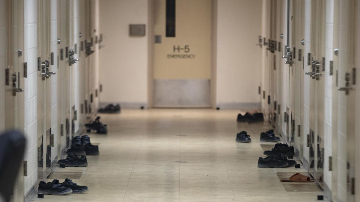 Resident's shoes on the floor outside individual rooms at the Sacramento County Youth Detention Facility.