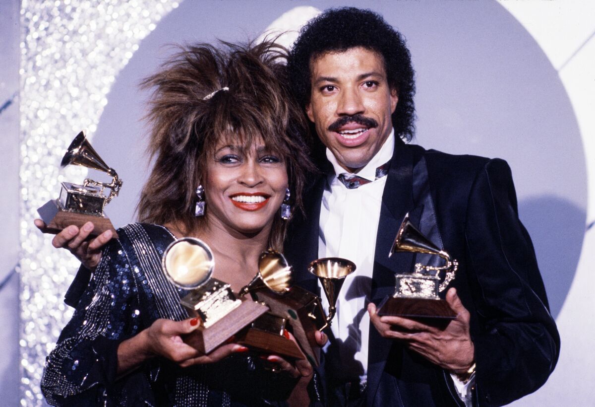 Tina Turner at left and Lionel Richie holding trophies 