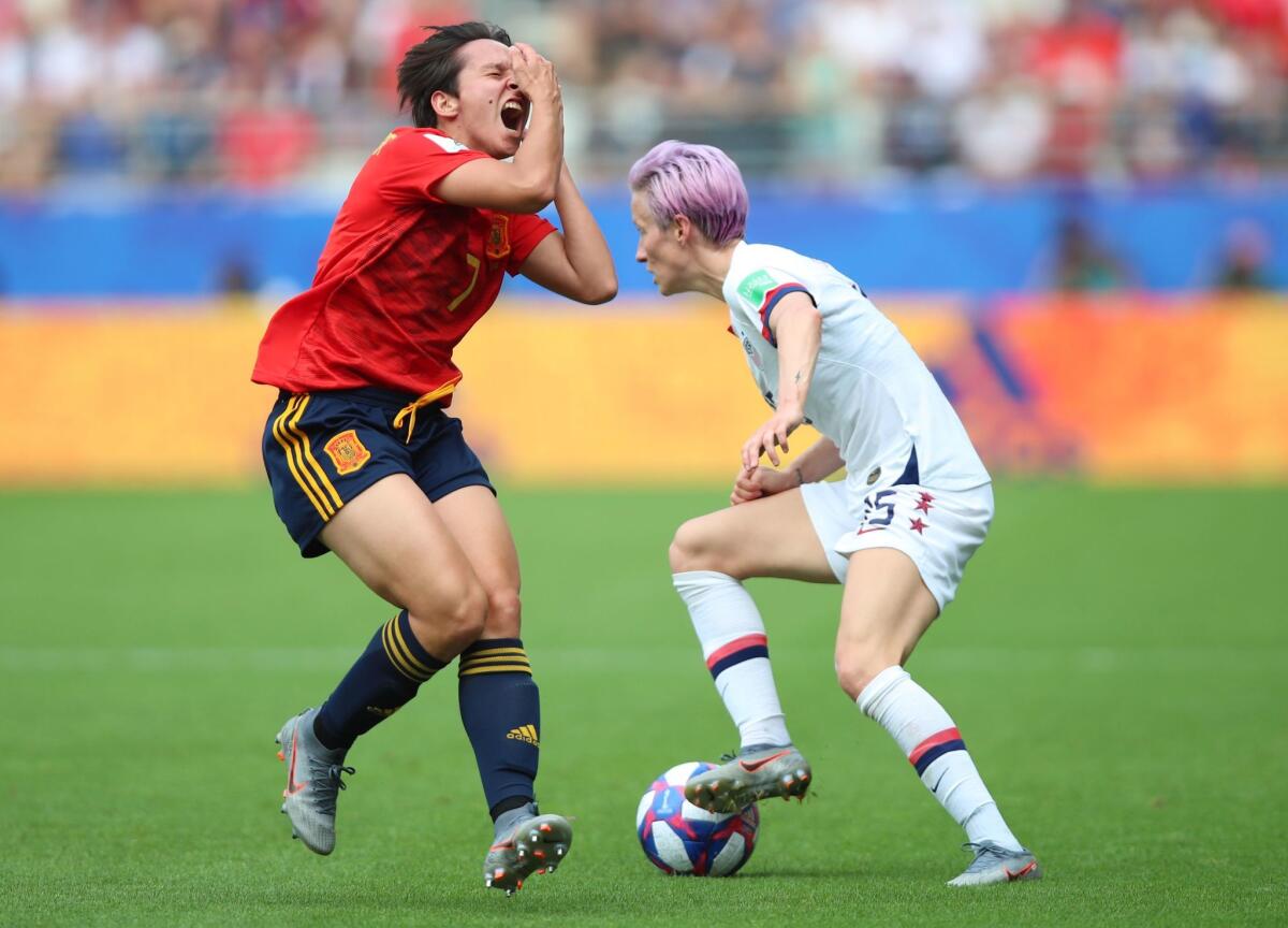 Megan Rapinoe of the U.S., right, got a yellow card for inadvertently slapping Spain’s Marta Corredera in the face.
