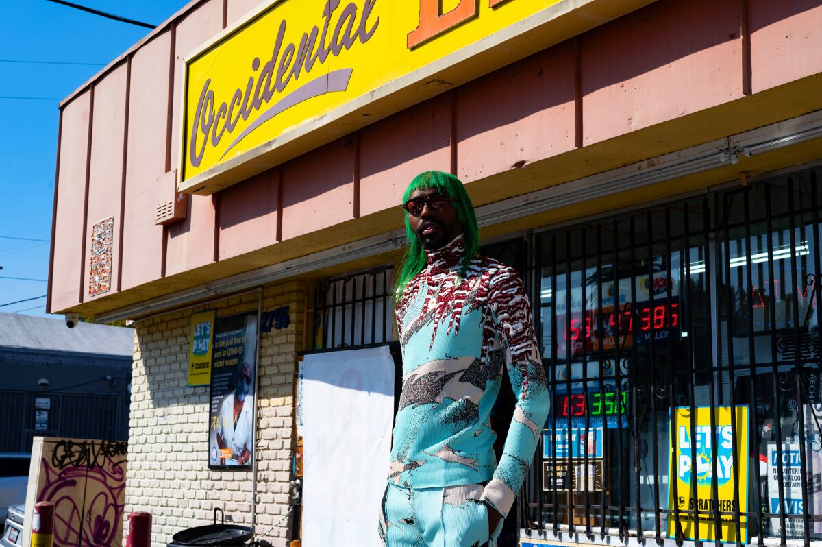 A person stands outside of strip mall
