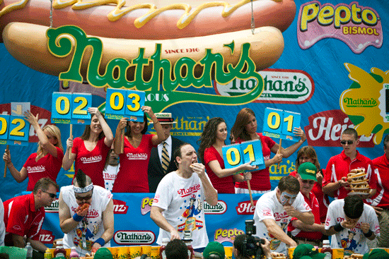 Joey Chestnut (C) competes in the 2011 Nathan's Famous Fourth of July International Hot Dog Eating Contest.