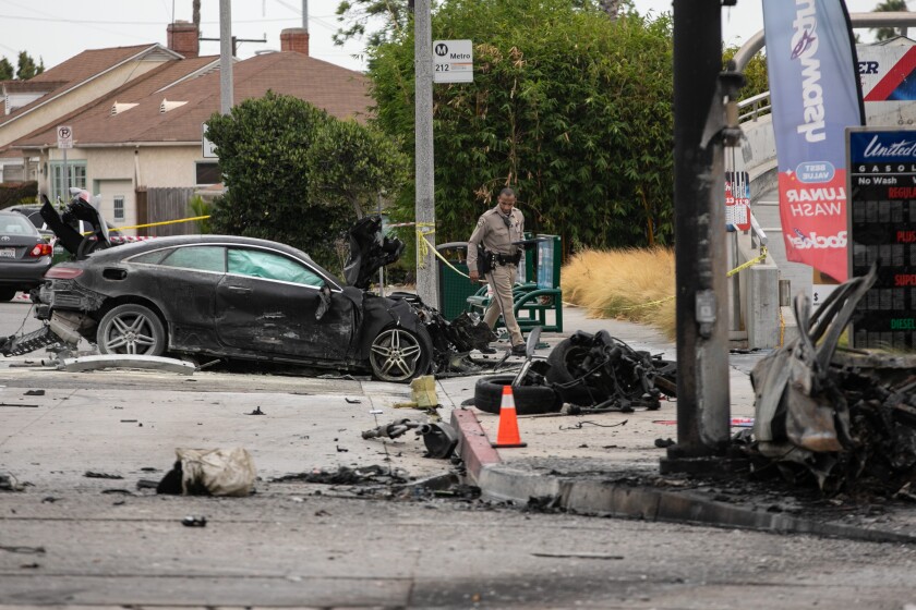 Law enforcement officials investigate a fiery fatal crash in Windsor Hills.