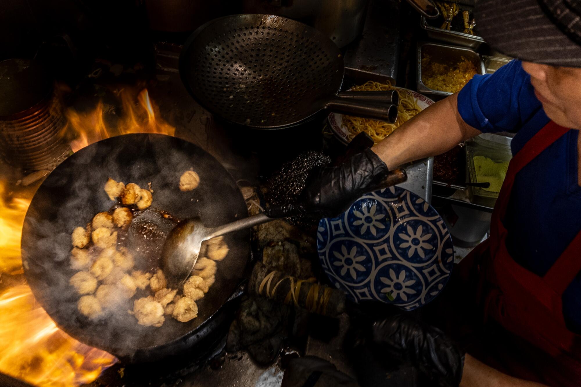 Kuei Chu, 75, cooking shrimp at the only wok in the restaurant. Chu comes from Taiwan, where he studied cooking.