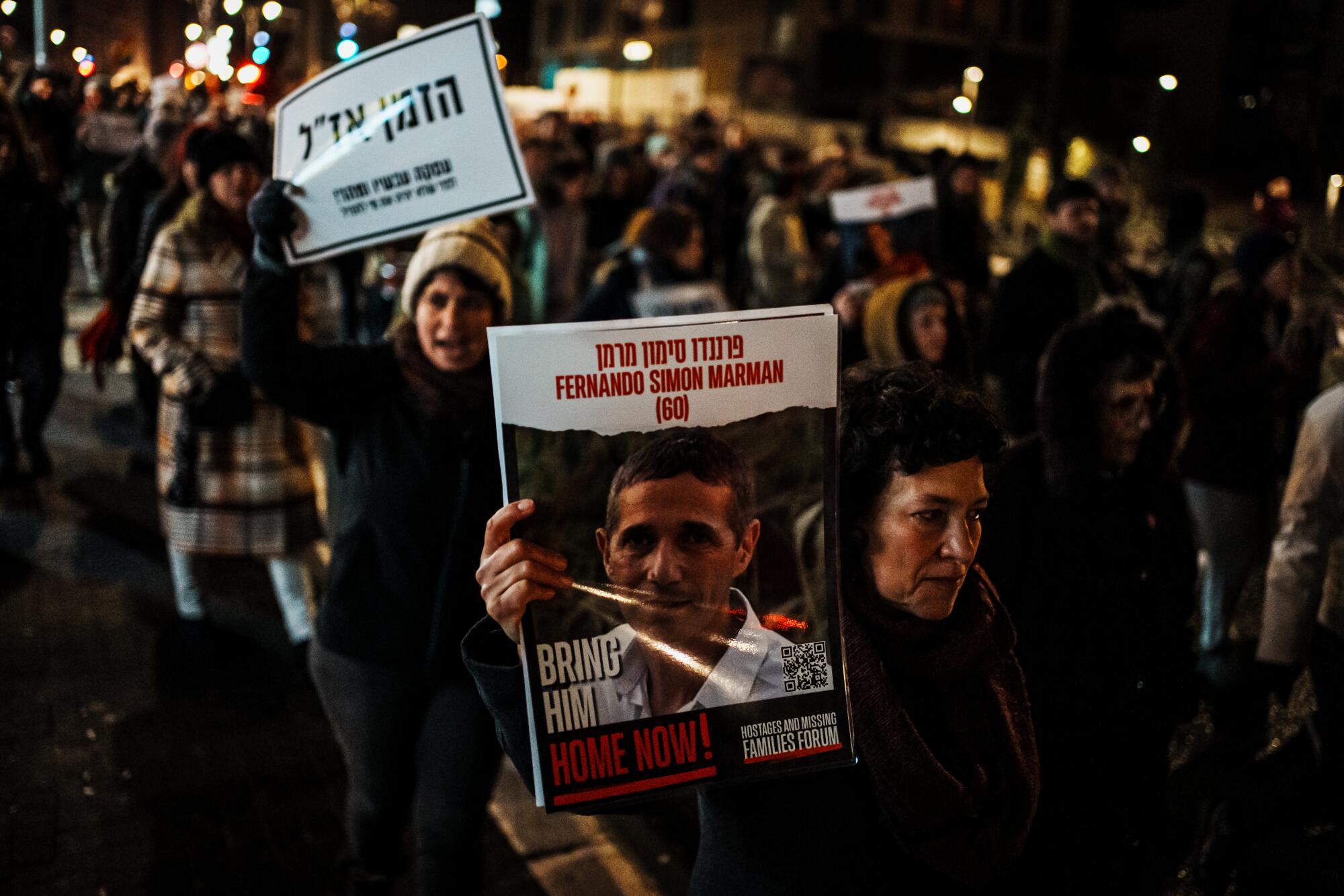 Protesters hold signs calling for hostages in Gaza during a march.