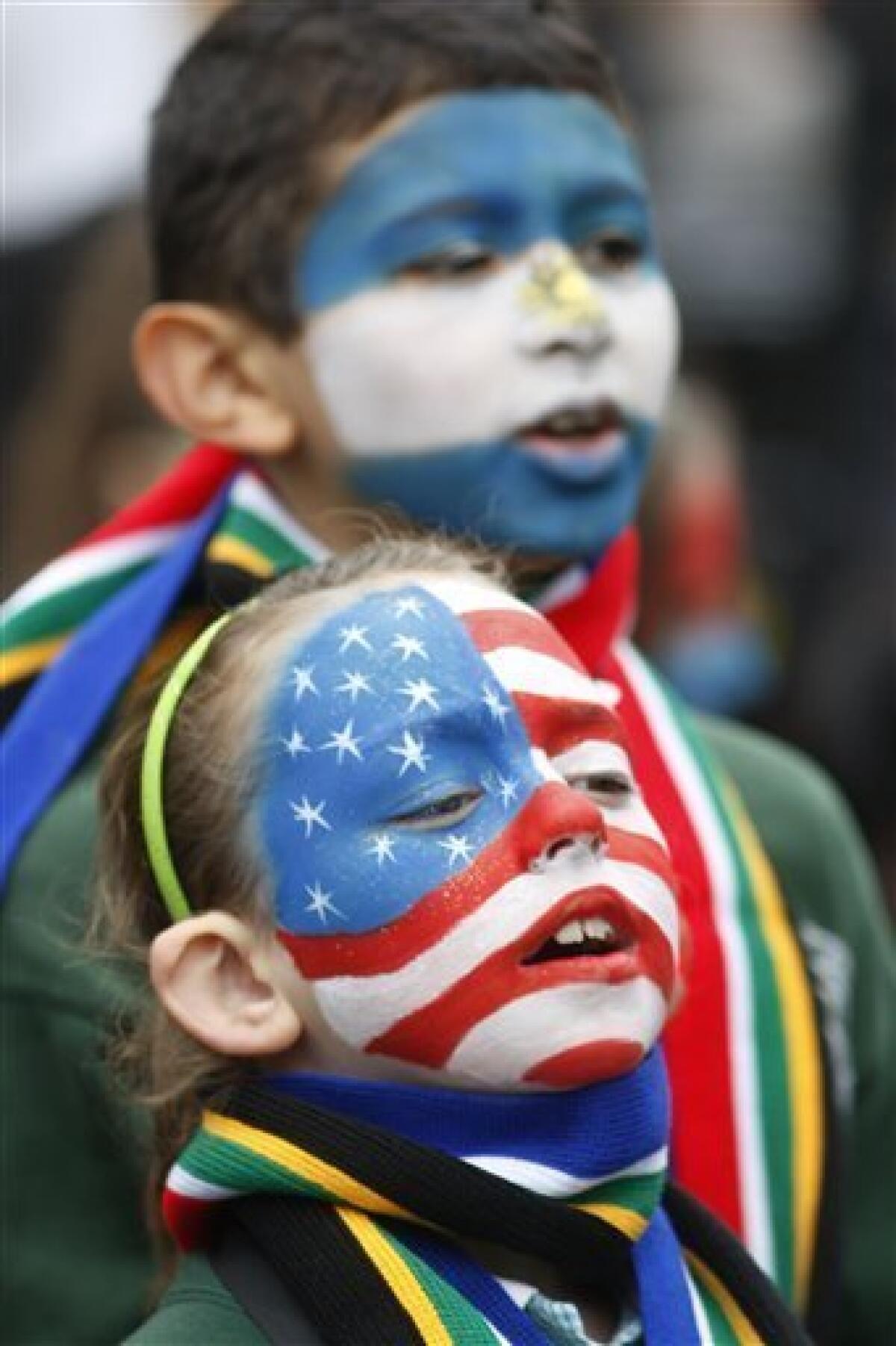 Pupils from St Joseph's Primary School with their faces painted in the U.S flag, bottom and a Argentinian flag wait for a special event to mark the start of South Africa World Cup Soccer at Trafalgar Square in London and to show support for England's bid to host the 2018 FIFA World Cup, Friday, June 11, 2010. (AP Photo/Sang Tan)