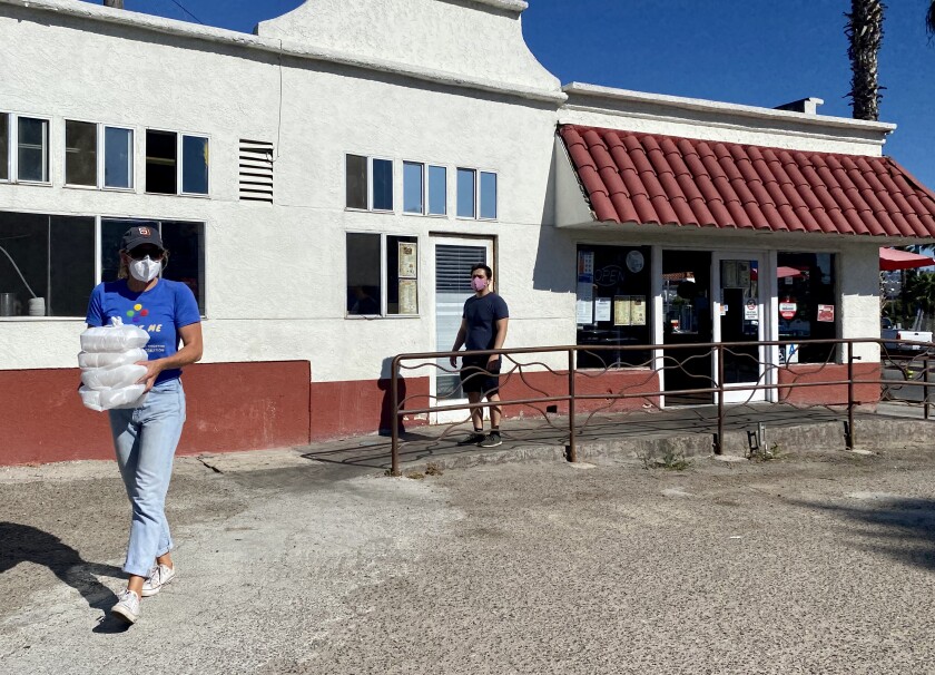 Casa Familiar workers take food from the restaurant for delivery to those in need.