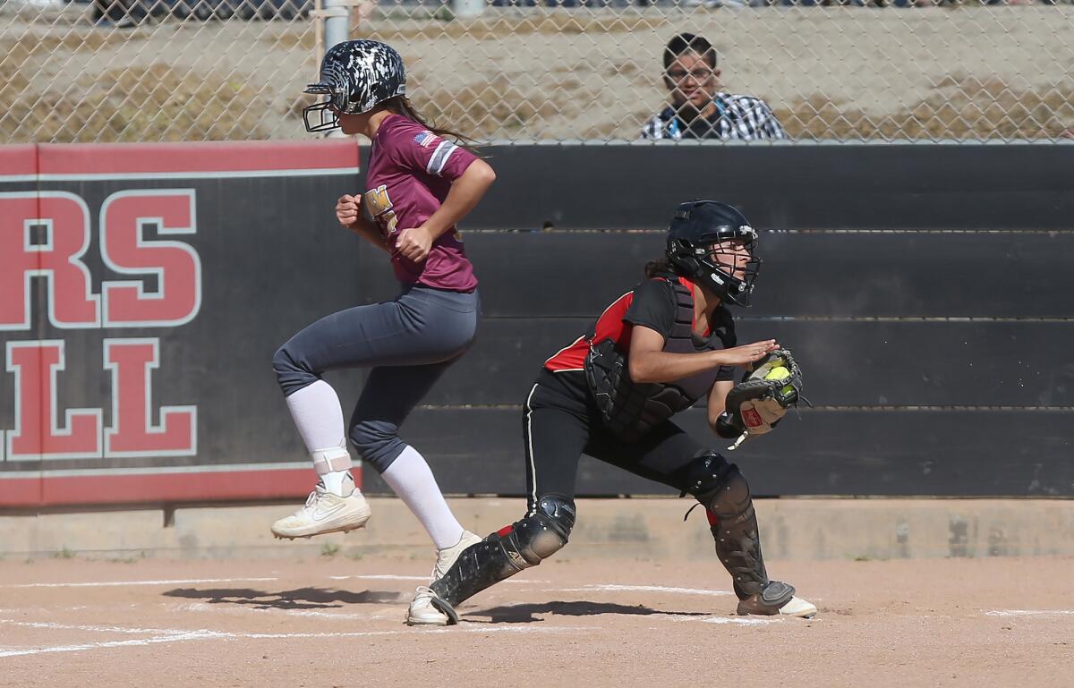 Ocean View's Ava Arce touches home plate and scores in a Golden West League game at Segerstrom on April 10, 2019.