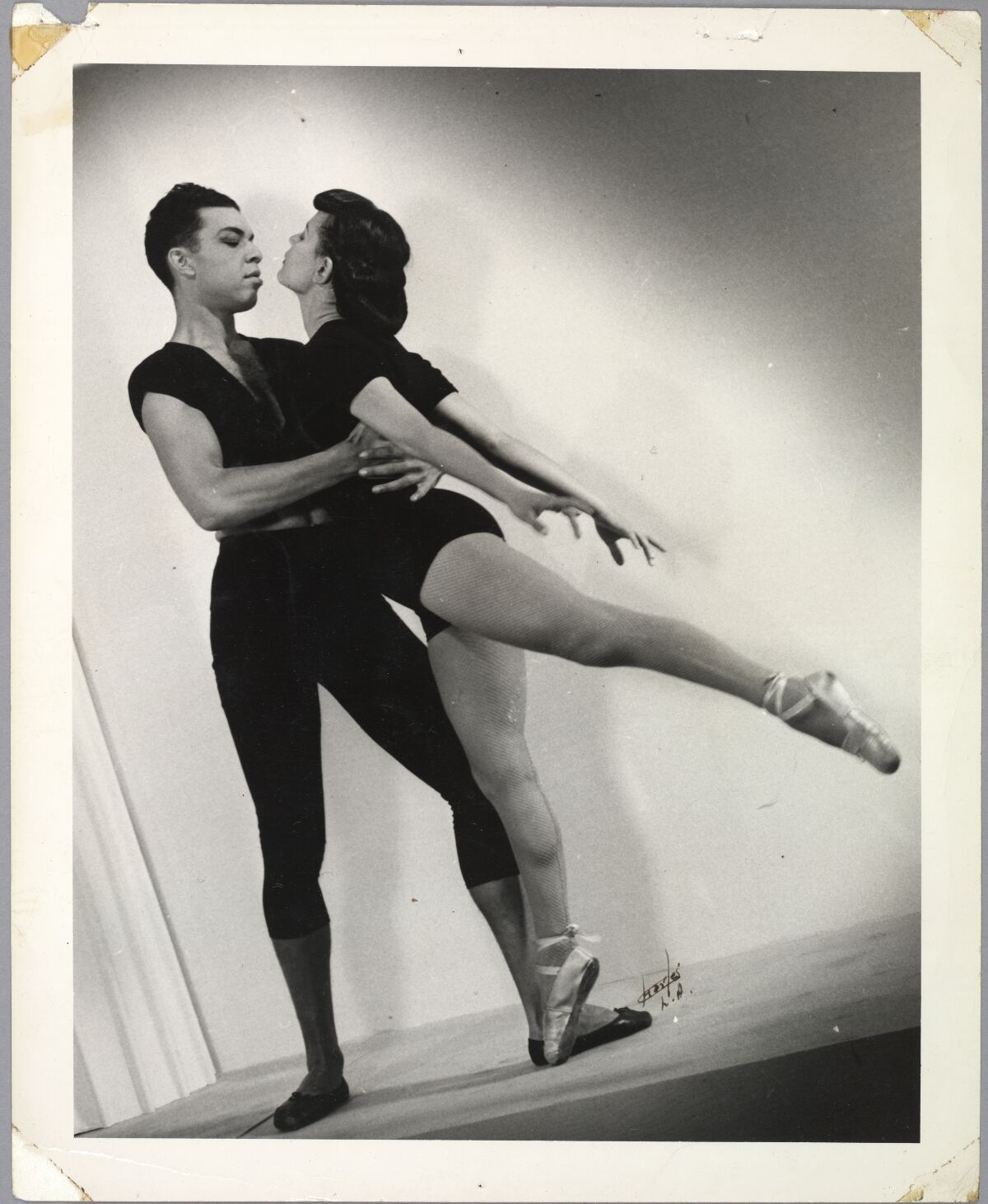 A vertical black-and-white full-body photo of ballet dancers James Truitte and Bernice Harrison in a dance pose. 
