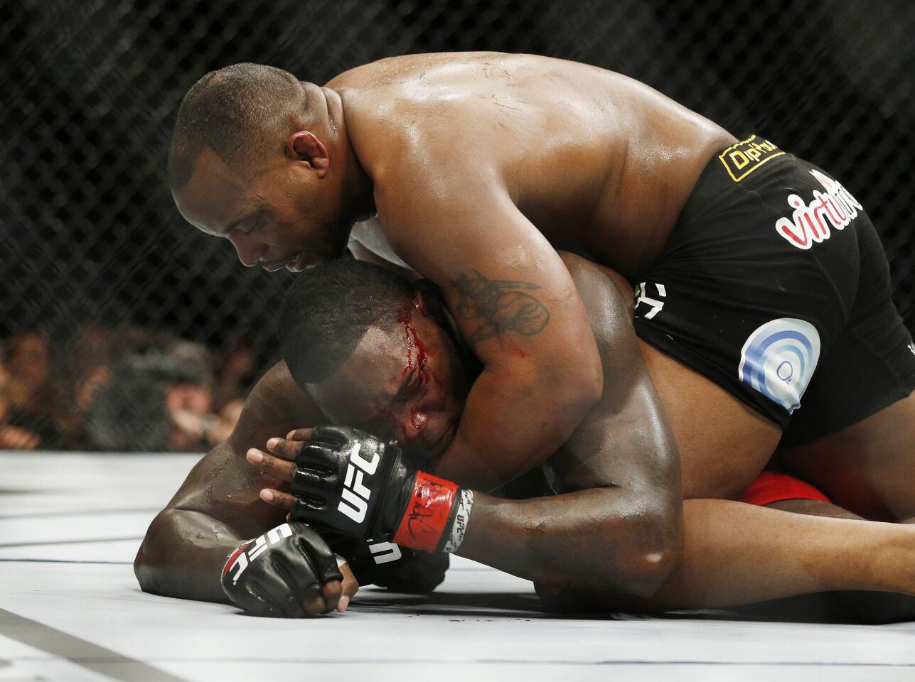 Daniel Cormier, top, works toward his third-round win by submission over Anthony Johnson at UFC 187 on May 23, 2015, in Las Vegas.