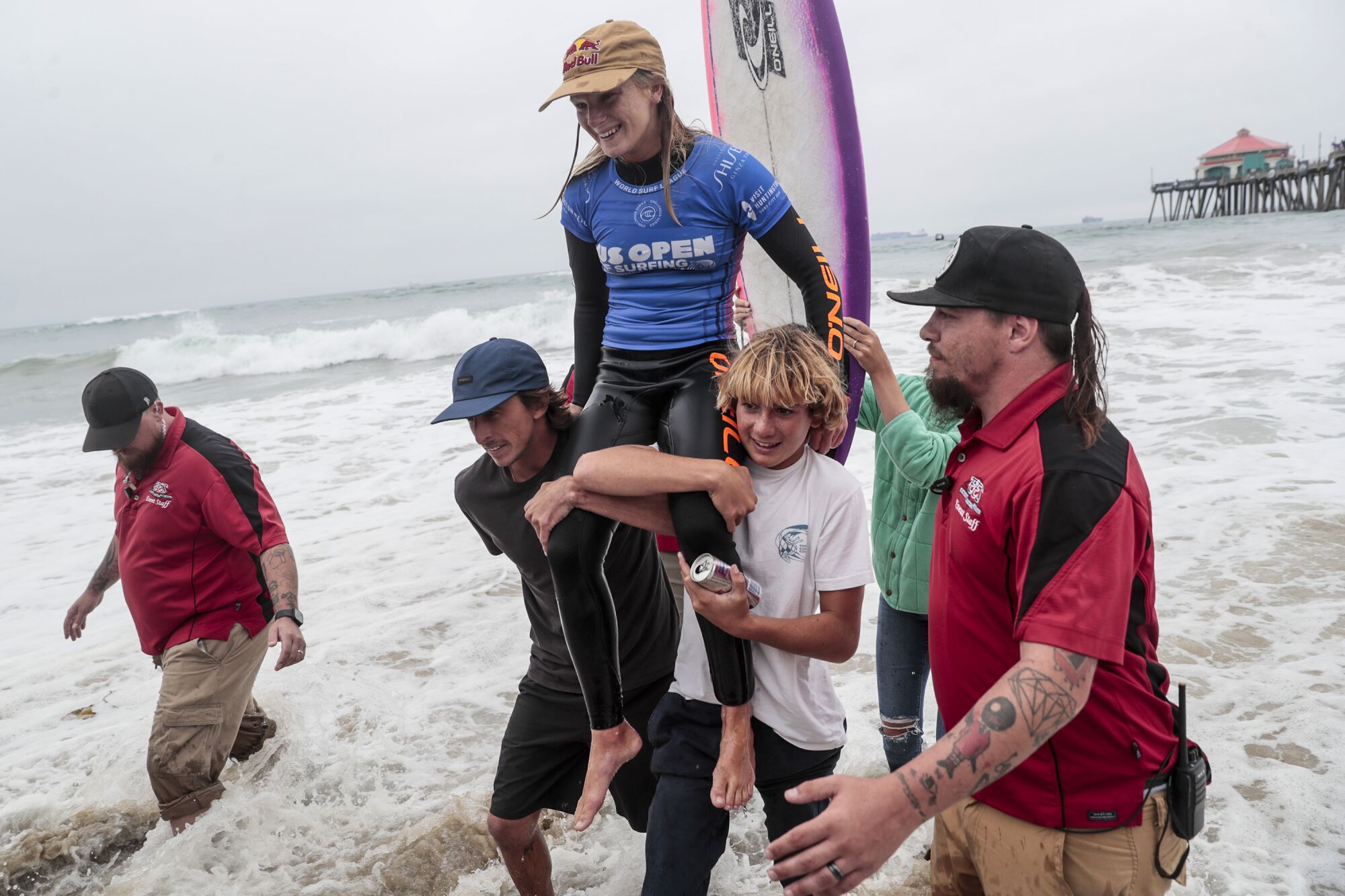 Caitlin Simmers is carried out of the surf after winning the final of the U.S. Open of Surfing at Huntington Beach.