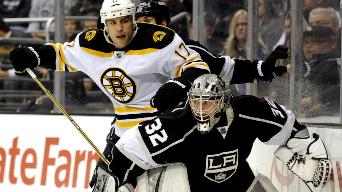 Kings goalie Jonathan Quick (32) keeps Milan Lucic (17) away from the puck during a game against the Bruins. Quick and Lucic will now be teammates after a trade with Boston on Friday.