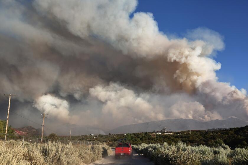 AGUANGA, CALIFORNIA - JULY 29: A vehicle drives as the Nixon Fire burns with evacuation orders in the area on July 29, 2024 near Aguanga, California. The wildfire in Riverside County has scorched 3,700 acres thus far. 726,000 acres have burned in California so far this year- more than five times the average for this point in the summer. (Photo by Mario Tama/Getty Images)