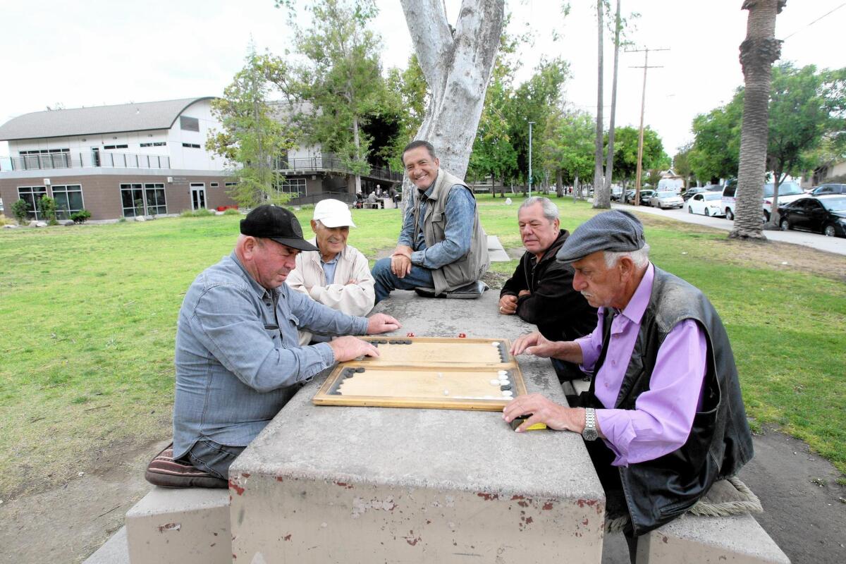 A group of men play backgammon at Maple Park in Glendale. The park is slated to have four shade structures installed by the end of the year.