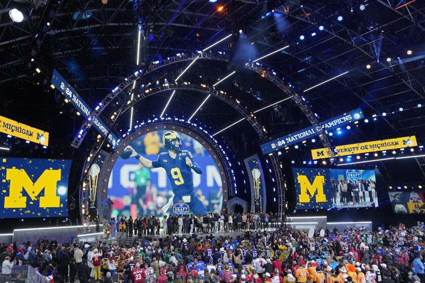 Michigan Football players stand on stage during the second round of the NFL football draft, Friday, April 26, 2024, in Detroit. (AP Photo/Paul Sancya)