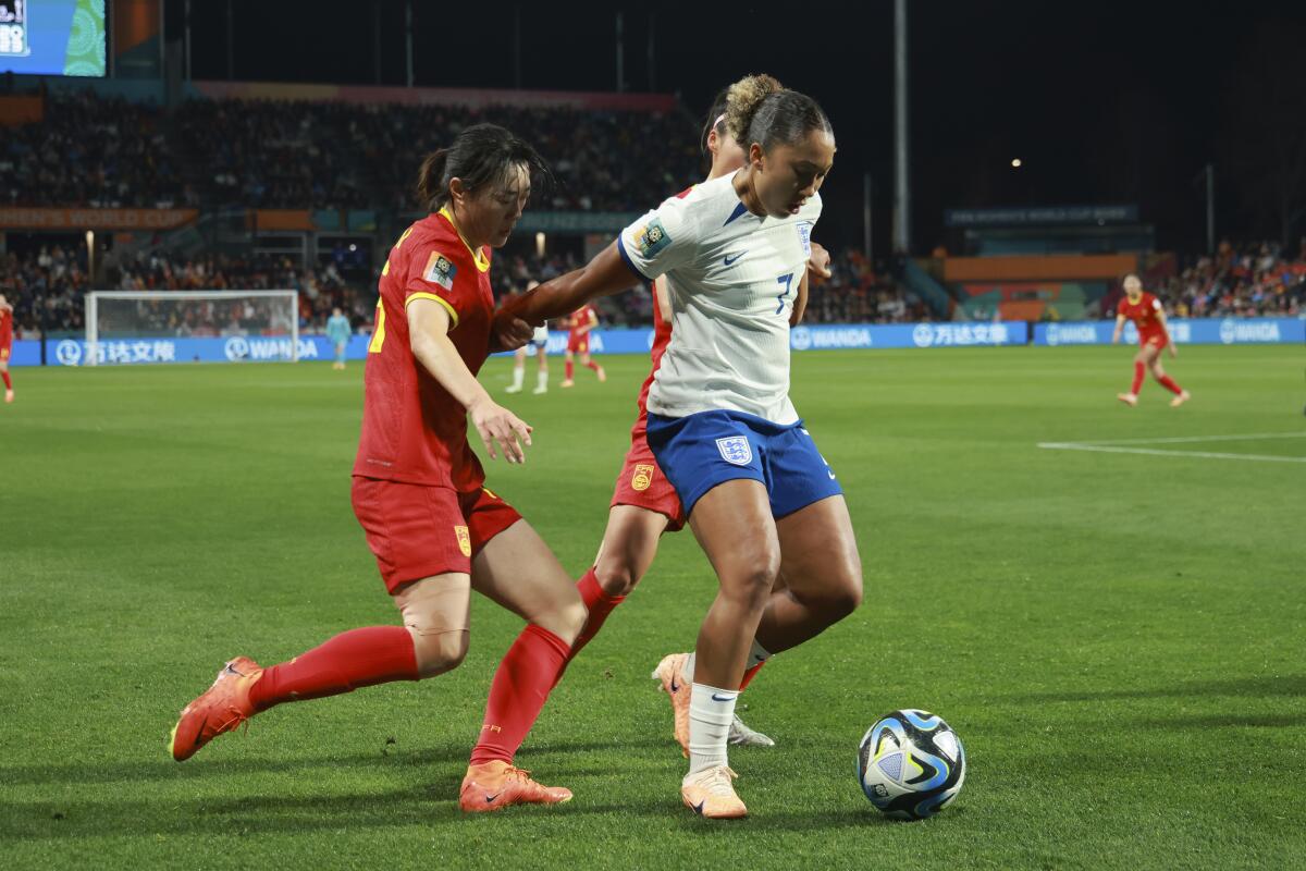 A player for England runs with the ball ahead of two players from China.