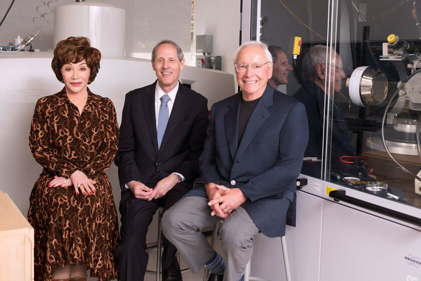 From left, Lynda Resnick, Caltech President Thomas F. Rosenbaum and Stewart Resnick in the Joint Center for Artificial Photosynthesis (JCAP) surface science lab at Caltech. Stewart and Lynda Resnick announced a historic $750 million pledge to Caltech to address and mitigate the effects of climate change. This is the largest commitment ever for sustainability research and the second-largest to a U.S. academic institution.