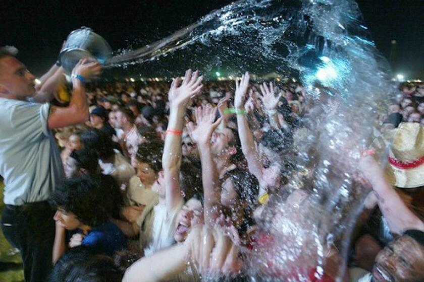 A festival worker cools off some fans in 2004.
