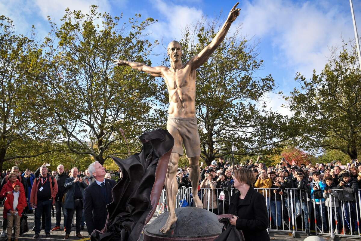 Swedish Soccer Federation general secretary Hakan Sjostrand, left, and Malmo municipal executive board chair Katrin Stjernfeldt Jammeh unveil a statue of Zlatan Ibrahimovic on Oct. 8.