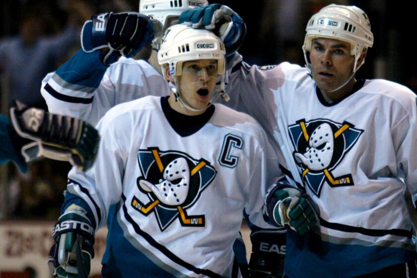 Allen J. Schaben –– – Mighty Ducks left wing Paul Kariya, center, celebrates his second period goal as he is congratulated by center Adam Oates, right, and teammates Wednesday, Feb. 19, 2003, at The Pond of Anaheim.