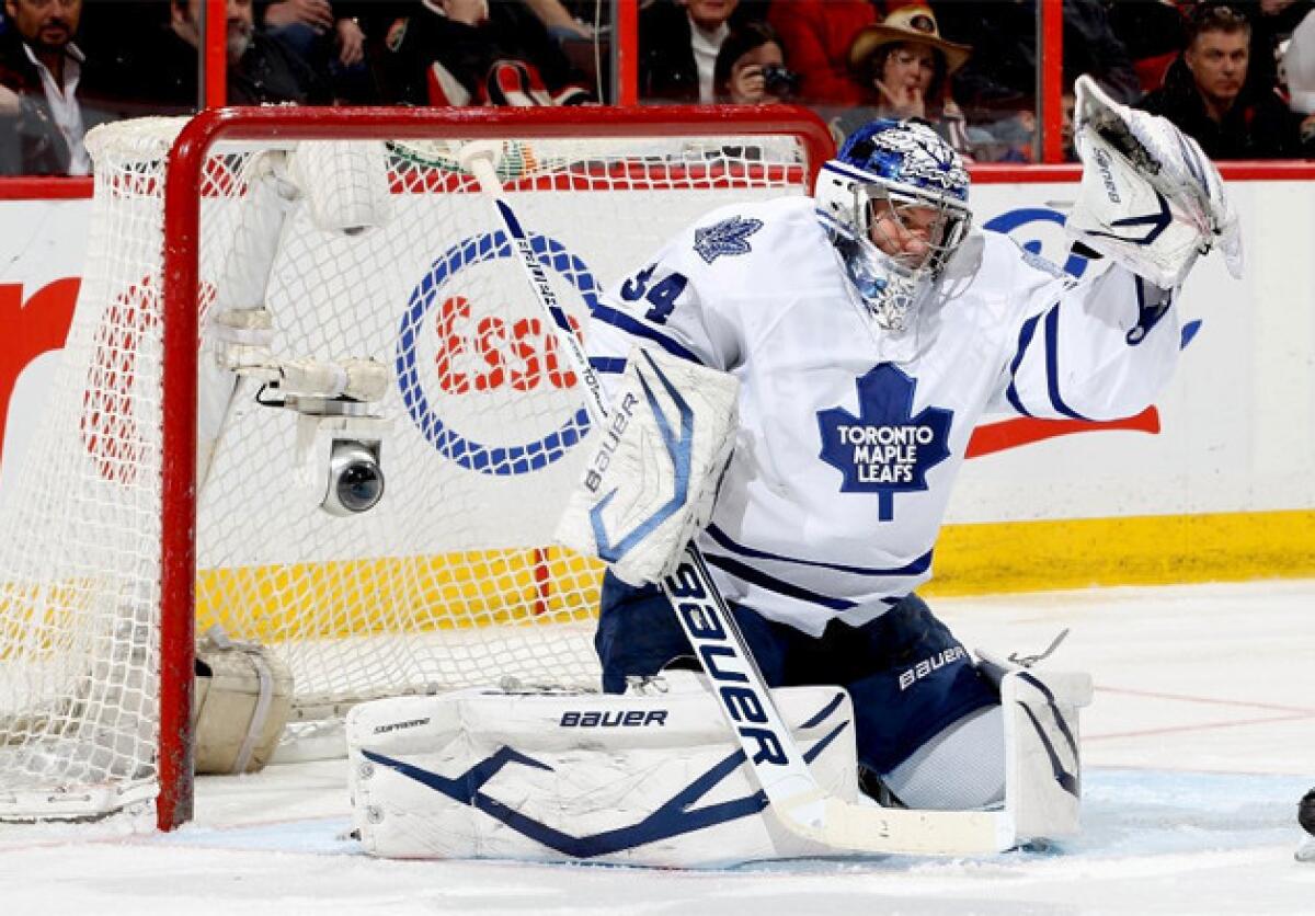 Toronto Maples Leafs goalie James Reimer makes a glove save off a tip during a game against the Ottawa Senators.