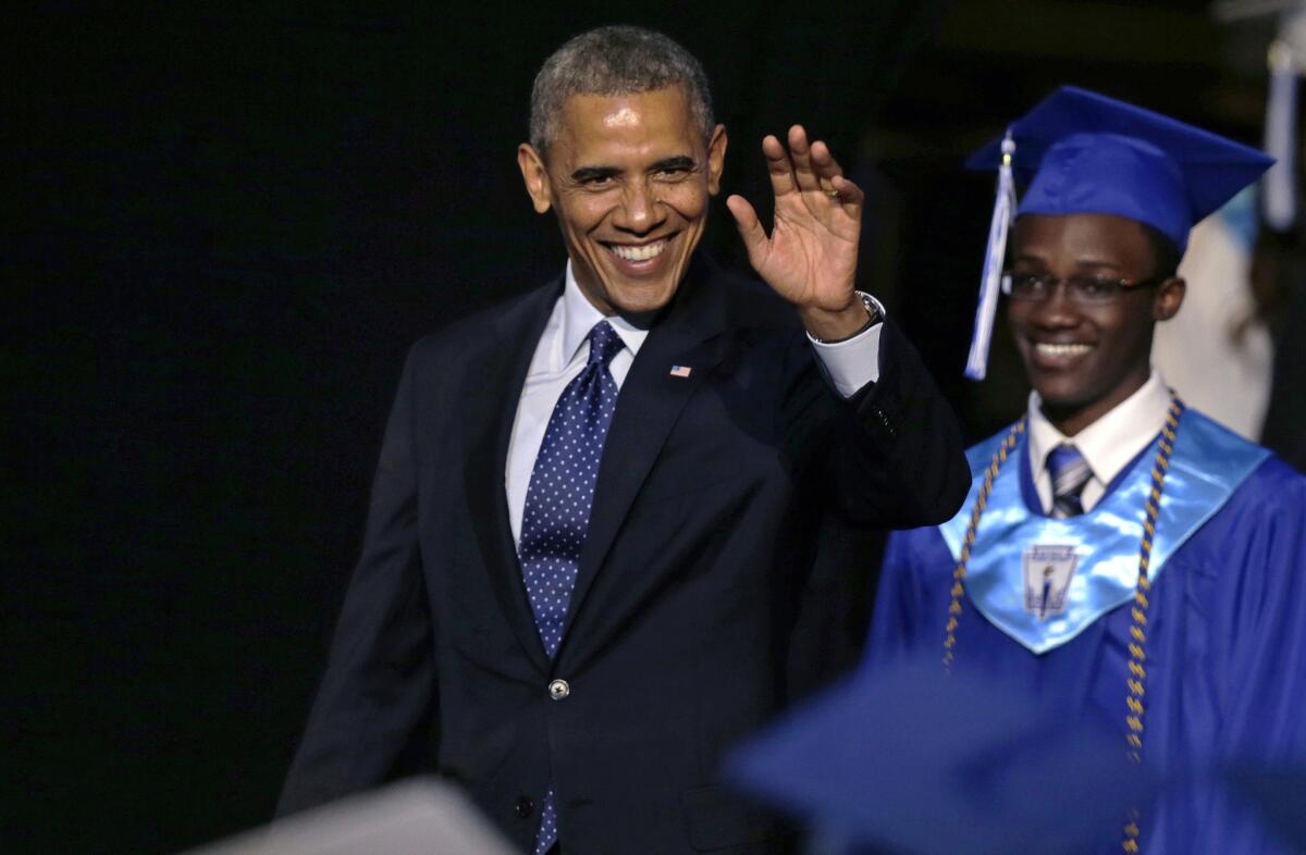 President Obama, followed by student body President Reginald Sarpong, arrives at the graduation ceremony for Worcester Technical High School in Worcester, Mass.
