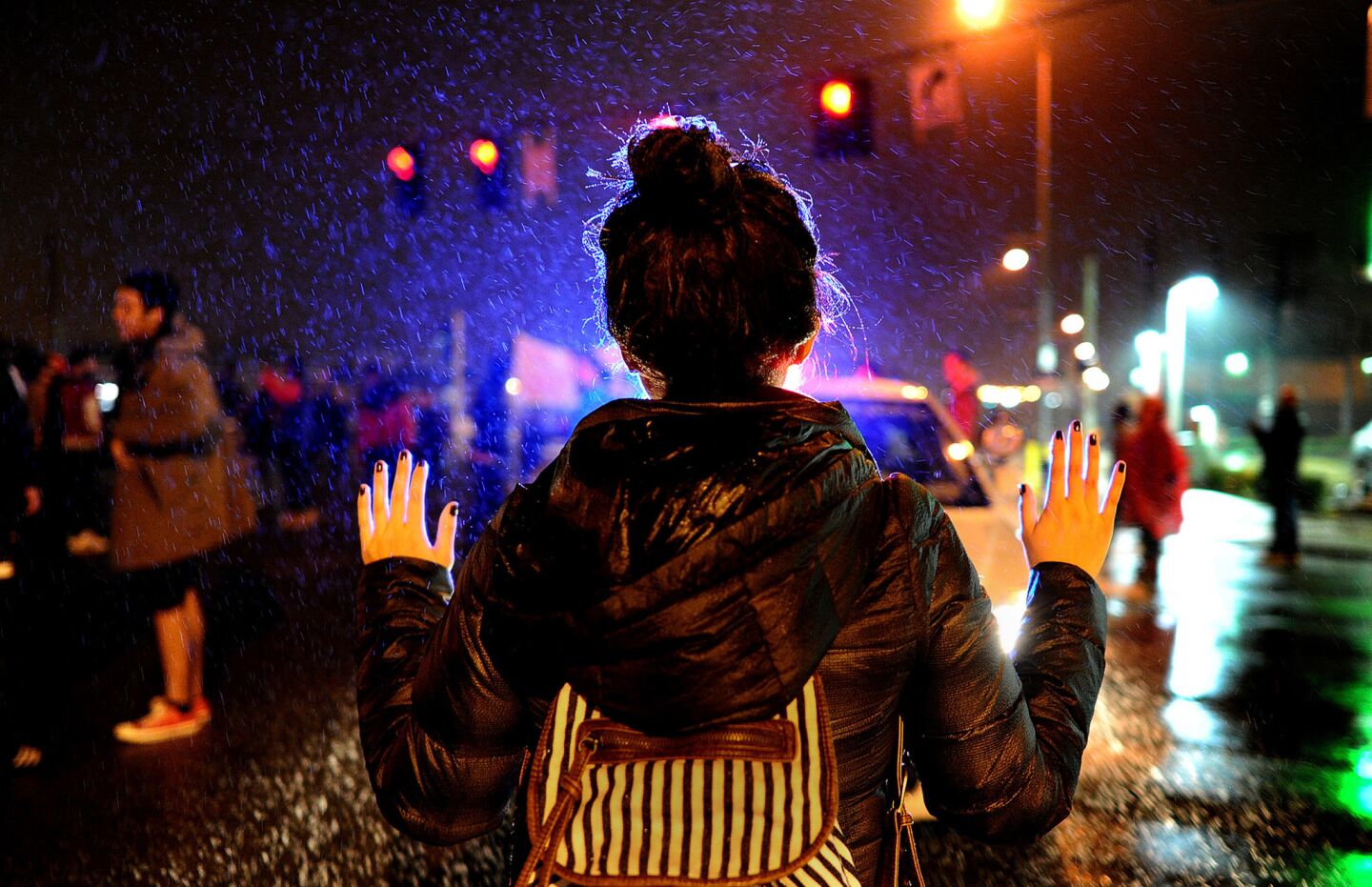 A protester holds her hands up in front of a police car during a demonstration in St. Louis, Mo., on Nov. 23.