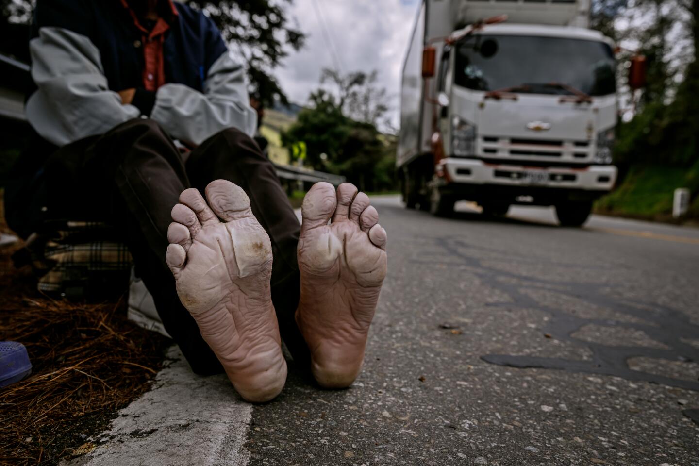 Ramon Cohil, 33, stretches his legs and airs out his feet, which are covered in blisters, near La Laguna, Colombia.