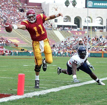 Matt Leinart leans for the endzone as Arizona's Rickey Parker looks on during the first quarter.