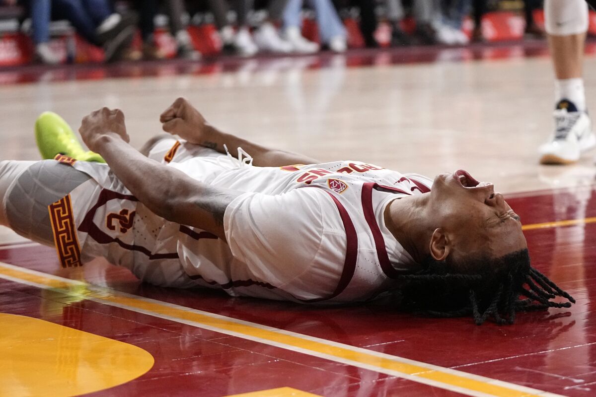 USC guard Boogie Ellis lets out a yell while lying on the court after scoring and drawing a foul.