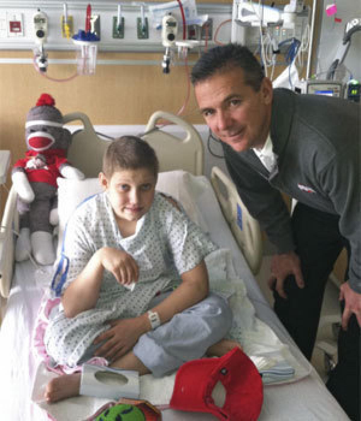 Ohio State football fan Grant Reed, left, gets a visit from Buckeyes Coach Urban Meyer at Nationwide Children's Hospital in Columbus, Ohio, in December.
