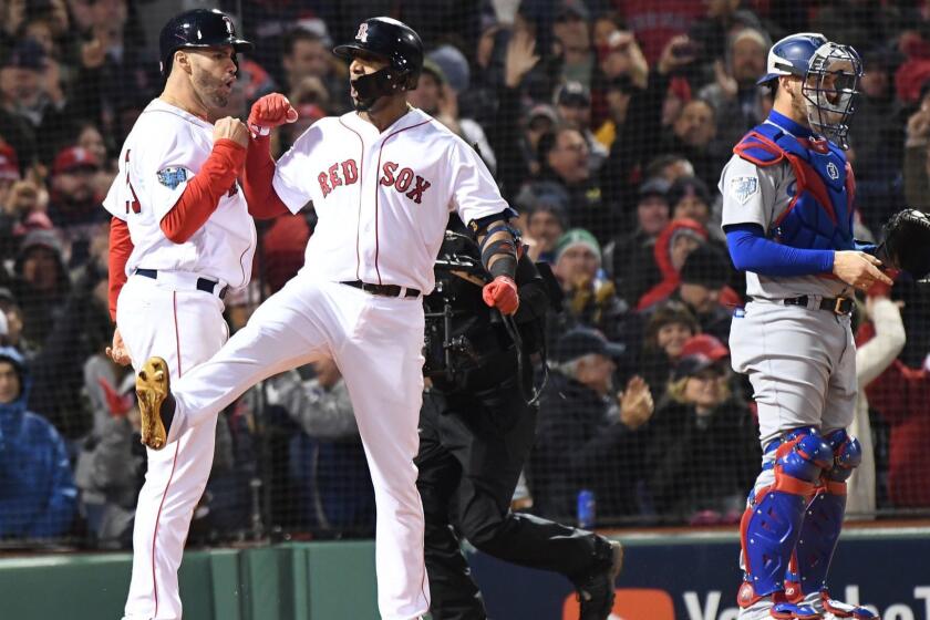 BOSTON, MA TUESDAY, OCTOBER 23, 2018 Red Sox Eduardo Nunez celebrates after hitting a three run home run as Dodgers Yasmandi Grandal waits in the 7th inning of game one of the World Series at Fenway Park.