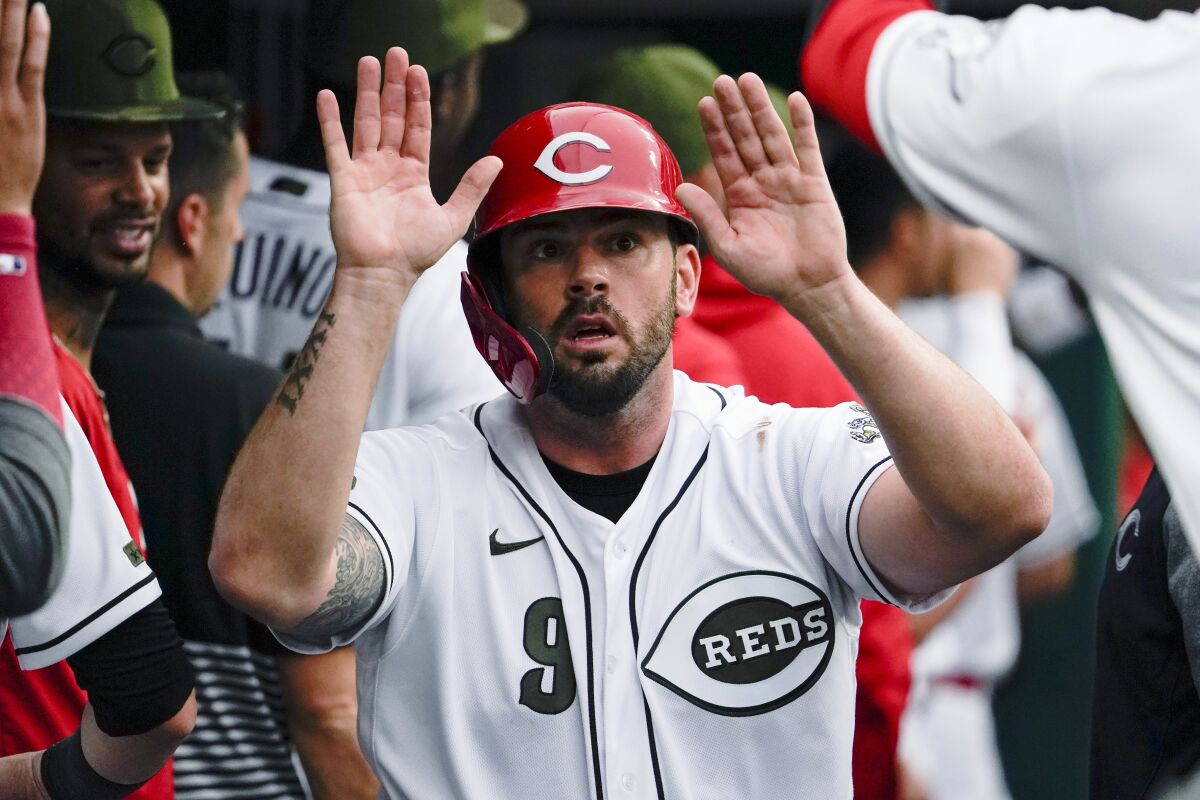 Cincinnati Reds' Mike Moustakas celebrates with teammates after scoring on a two-run single by Kyle Farmer during the first inning of the team's baseball game against the Pittsburgh Pirates in Cincinnati on Friday, Aug. 6, 2021. (AP Photo/Jeff Dean)
