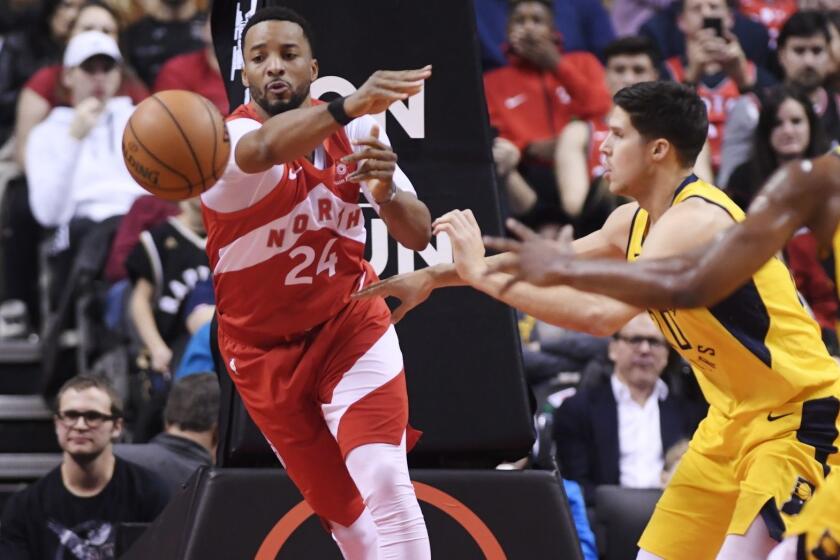 Toronto Raptors forward Norman Powell (24) passes the ball as Indiana Pacers forward Doug McDermott (20) and forward Thaddeus Young (21) look on during second half NBA basketball action in Toronto on Sunday, Jan. 6, 2019. (Nathan Denette/The Canadian Press via AP)