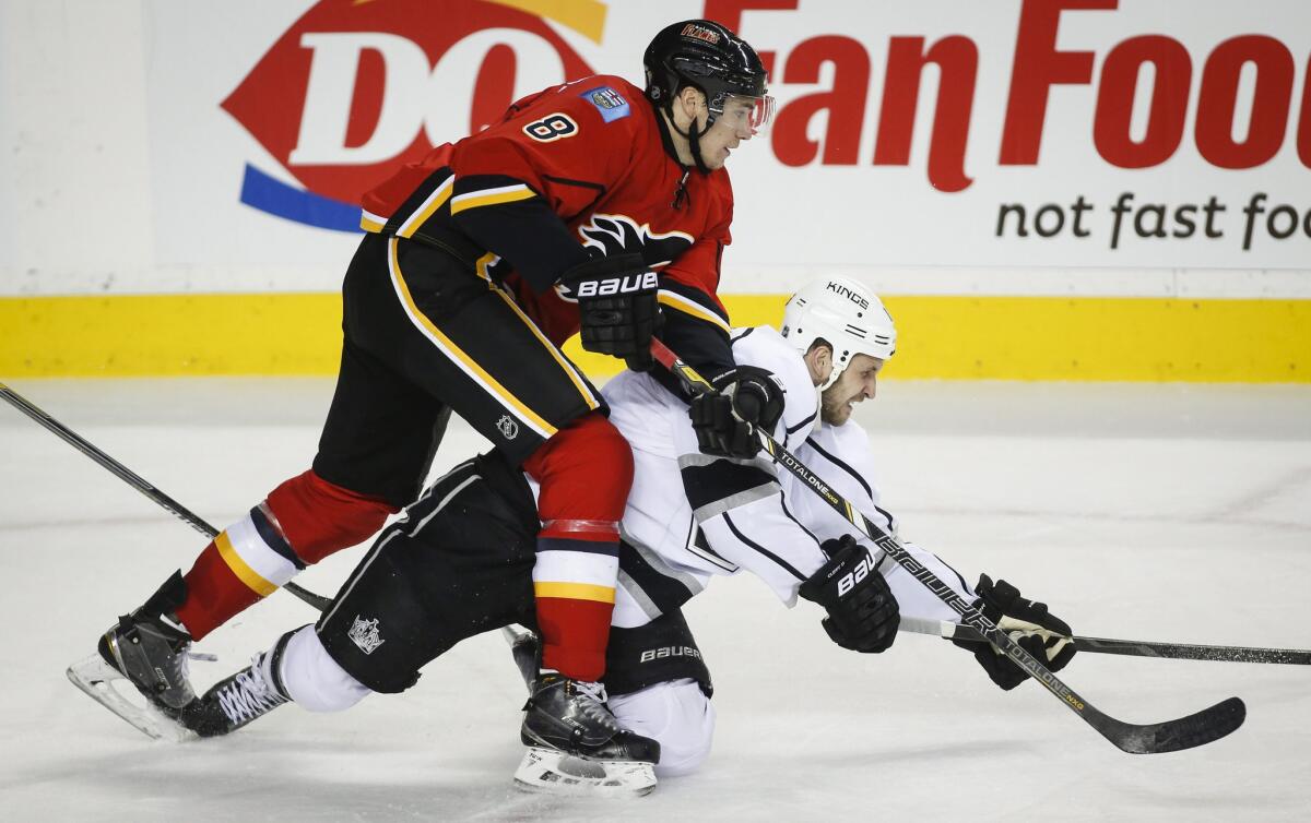 Flames center Joe Colborne bowls over Kings forward Kyle Clifford. The Flames have rebounded from a slump and are now ahead of the Kings in the playoff standings.