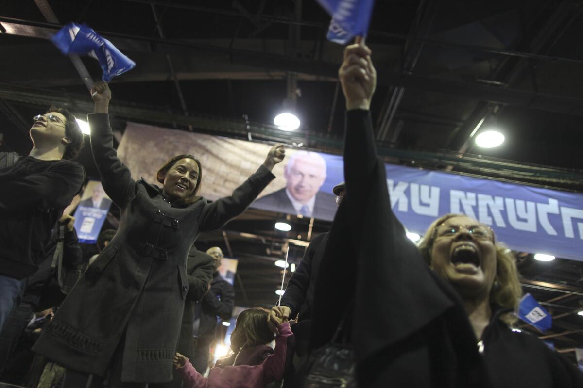 Supporters of Israeli Prime Minister Benjamin Netanyahu celebrate in Tel Aviv on Tuesday. His coalition appeared to have the edge over rivals in the day's election, according to exit polls.