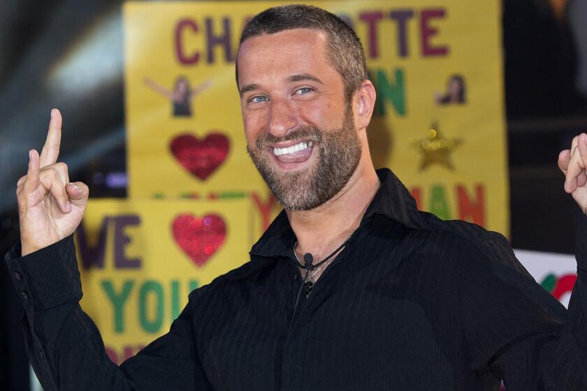 Dustin Diamond smiling and making a "rock on" gesture with his hands