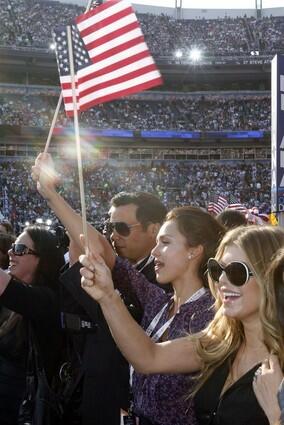 Jessica Alba, center, her husband Cash Warren, left, and singer Fergie wave flags during the final session of the Democratic National Convention at Invesco Field in Denver.