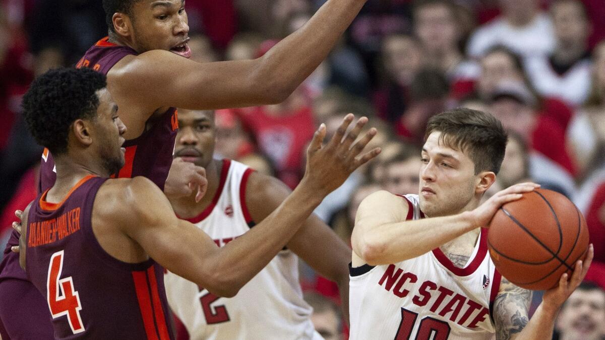 North Carolina State's Braxton Beverly is trapped by Virginia Tech's Nickeil Alexander-Walker (4) and Kerry Blackshear Jr. during the second half Saturday.