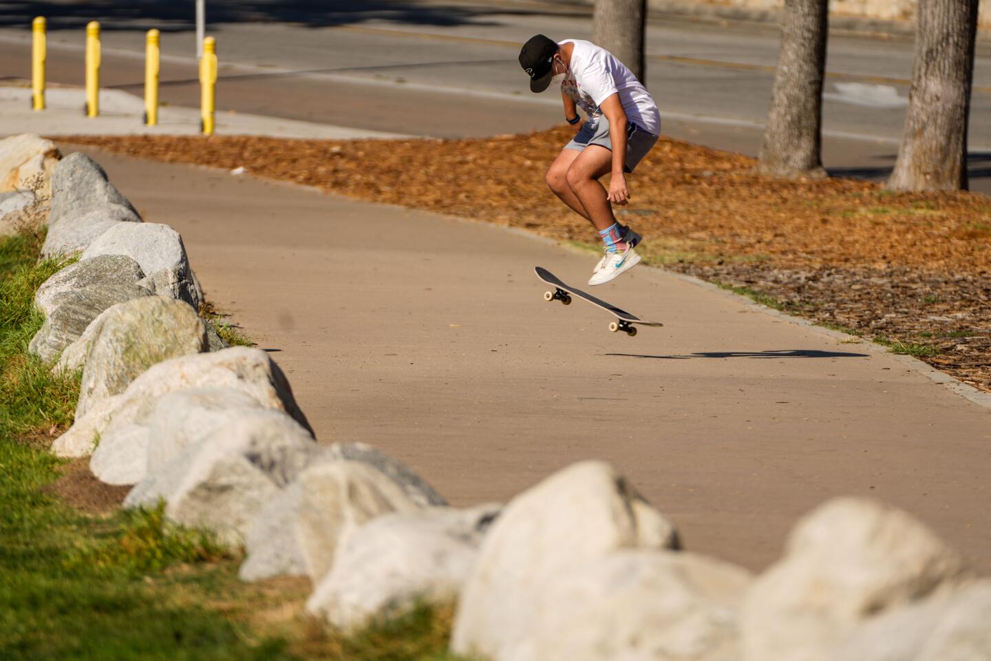 A skateboarder jumps while skating Tuesday along the sidewalk near the Rose Bowl in Pasadena.