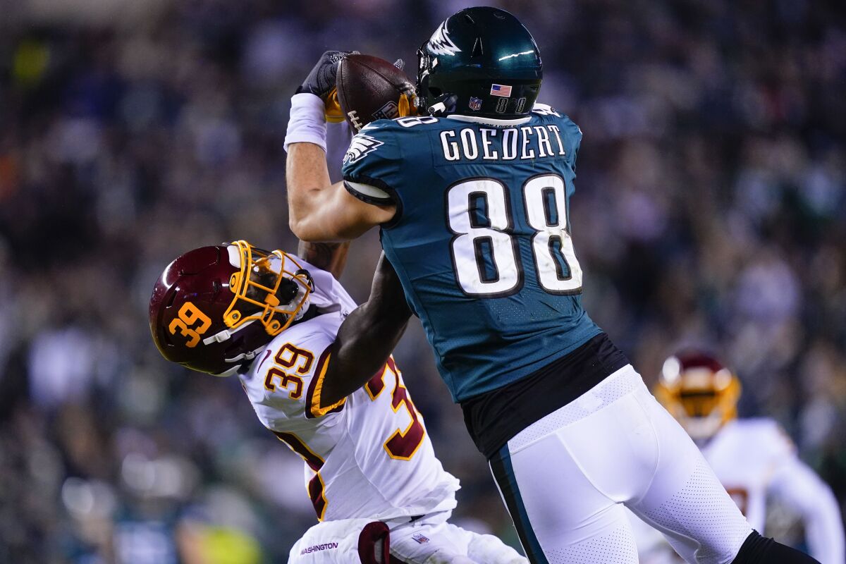 Philadelphia Eagles' Dallas Goedert, right, makes a catch while Washington Football Team's Jeremy Reaves defends during the first half of an NFL football game, Tuesday, Dec. 21, 2021, in Philadelphia. (AP Photo/Matt Rourke)