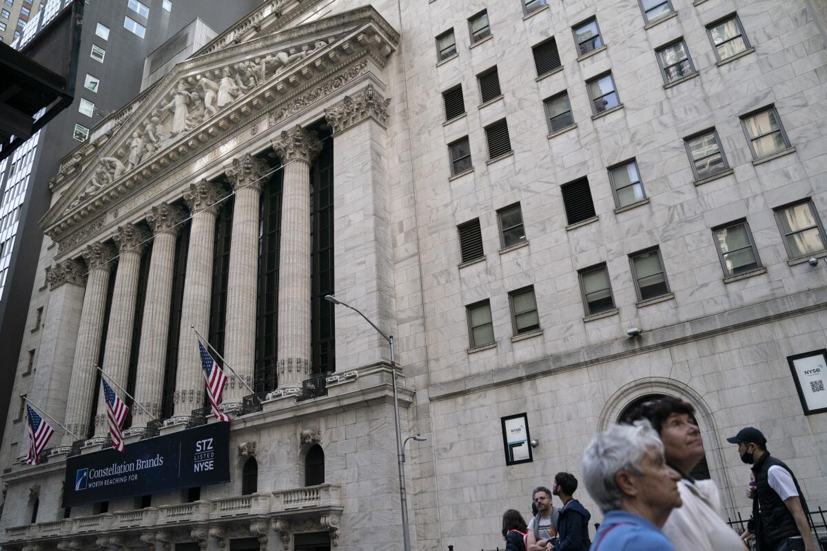 Pedestrians pass the New York Stock Exchange.