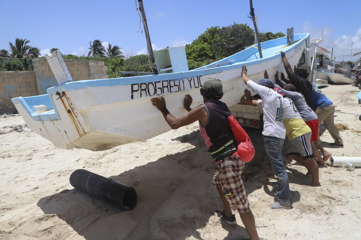 People relocate a boat ahead of the arrival of Hurricane Beryl in Progreso, Mexico