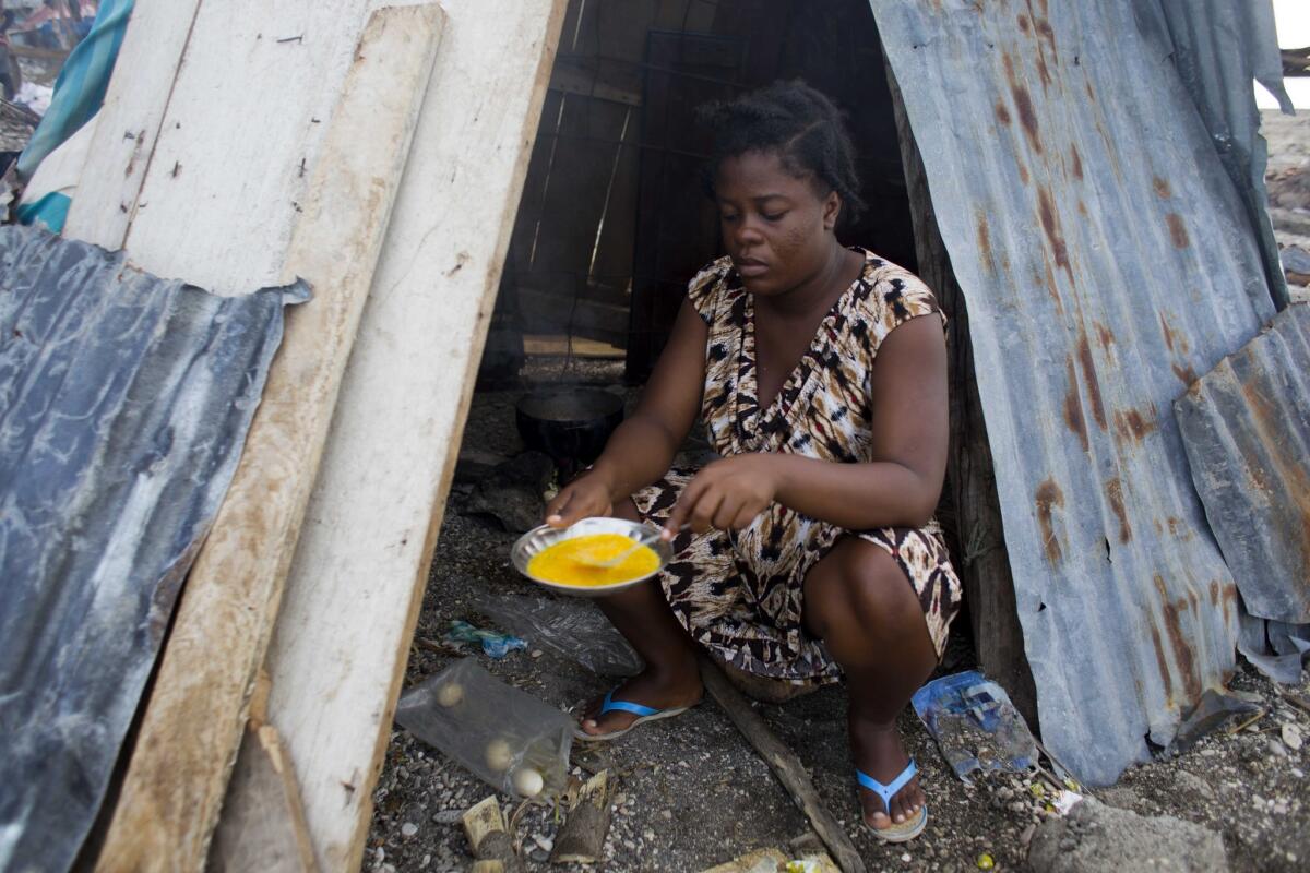 En esta imagen del 1 de noviembre de 2016, Nathanaelle Bernard, de 19 años y embarazada de 7 meses, cocina una tortilla en una choza que comparte con familiares en Coteaux, Haití. (AP Foto/Dieu Nalio Chery)