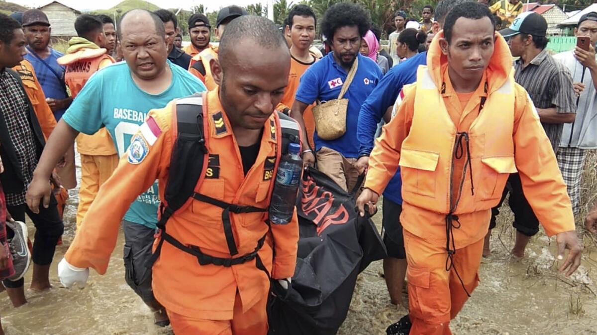 A rescue crew carries the body of a flood victim in Sentani, Indonesia.