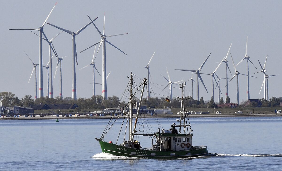 FILE - A fisher boat passes wind turbines between the island Langeoog and Bensersiel at the North Sea coast in Germany, on May 15, 2019. Four European Union countries plan to build North Sea wind farms capable of producing at least 150 gigawatts of energy by 2050 to help cut carbon emissions that cause climate change, Danish media reported Wednesday, May 18, 2022. (AP Photo/Martin Meissner)