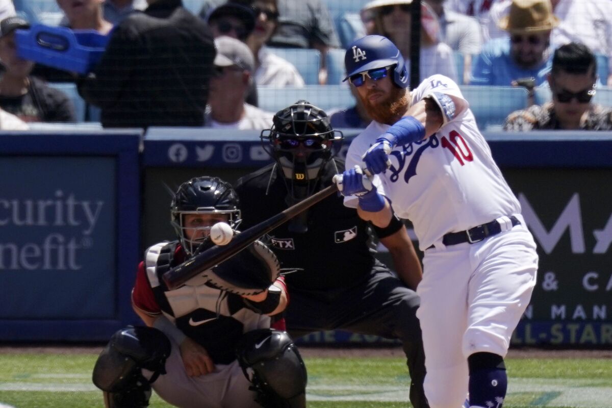 Dodgers' Justin Turner hits a three-run home run as Arizona Diamondbacks catcher Daulton Varsho watches.